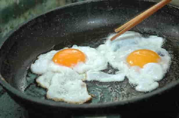 Ốp trứng trong chảo dầu, đun lửa nhỏ để trứng chín đều - mì xào trứng